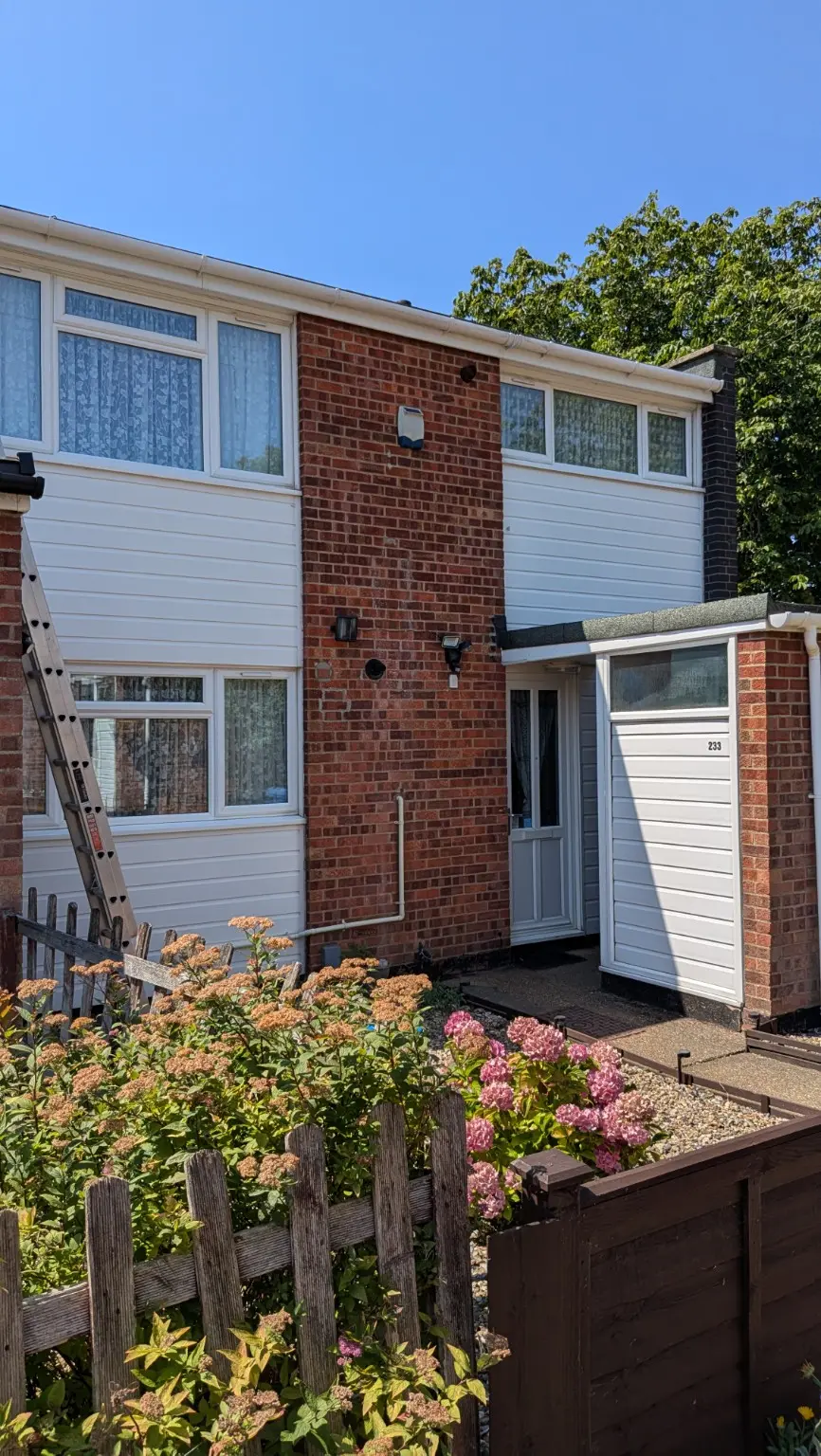 House exterior guttering fascia and white cladding after professional cleaning