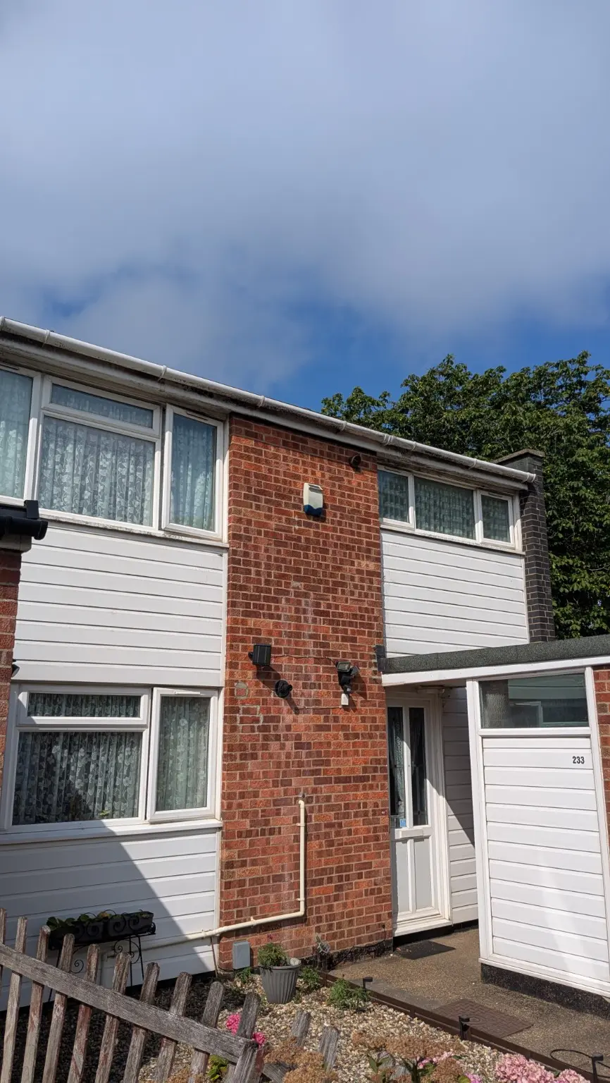 House exterior guttering fascia and white cladding before professional cleaning